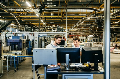 Ingenieure hinter mehreren Computer-Monitoren